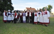 Czlonkowie zespolow Tradycja i Jarzebinki podczas festiwalu w Kramsku. Zdjecie w plenerze na lace.