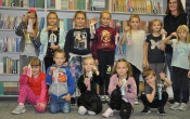 Dwanaścioro dzieci - uczestników zajęć- prezentuje swoje prace w towarzystwie instruktorki pani Pauliny