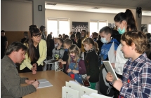 Krzystzof Petekek wpisujacuy dedykacje uczestnikom spotkania