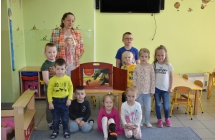 Dzieci pozuja przy teatrzyku z bibliotekarka