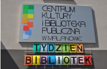 Tablica z logo Centrum Kultury i Biblioteka Publiczna w Malanowie, pod spodem napis tydzien bibliotek
