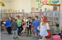 Przedszkolaki szukaja na polkach ksiazek o bohaterach bajek