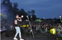 Mezczyzna na scenie trzyma plyte, w tle tlum ludzi