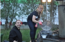 Kobieta i mezczyzna nalewaja zupe z kuchni polowej
