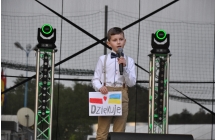 Chlopiec spiewa, trzyma kartke z napisem dziekuje i flagami Polski i Ukrainy