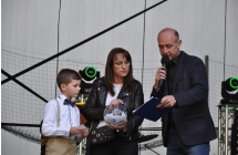 Chlopiec losuje nagrode ze szklanej kuli. obok stoi kobieta i konfernasjer