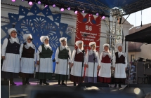 Osiem kobiet z zespolu Tradycja na scenie, w strojach ludowych