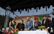Kobieta wraz z mezczyznami krojaca i ukladajaca chleb 