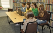 Piec dziewczynek pracujacych na tabletach i laptopach
