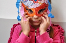 Dziewczynka trzymajaca maske karnawalowa